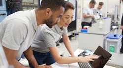 Two Engineers Using CAD Programming Software On Laptop Two Engineers Using CAD Programming Software On Laptop