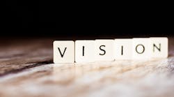 The word 'vision' in black on white tiles. The word 'vision' in black on white tiles.