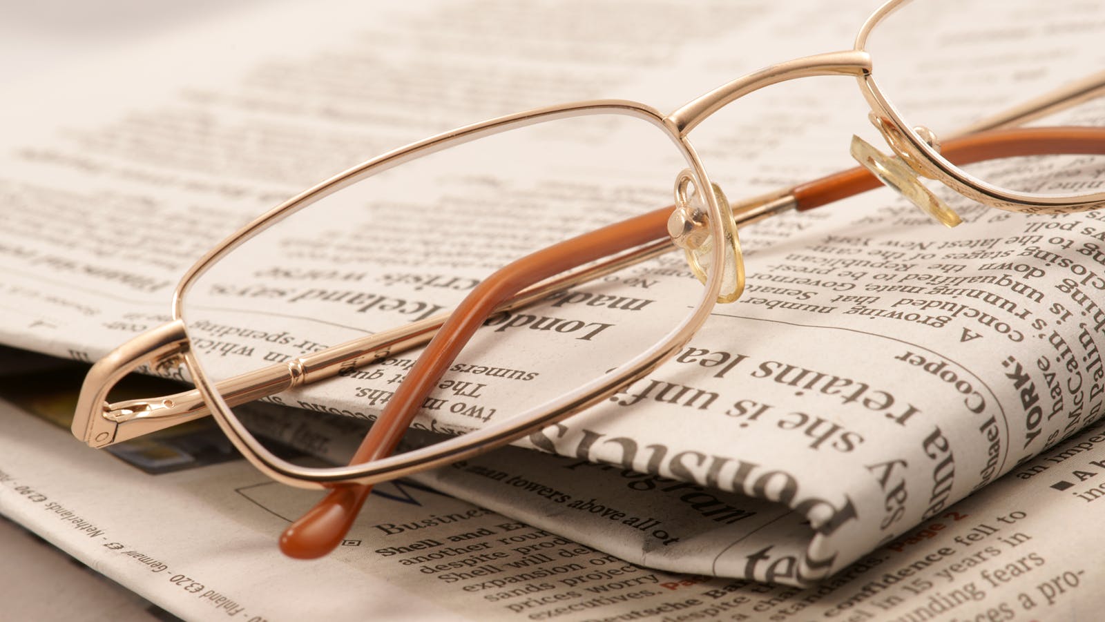 eyeglasses resting on a folded newspaper