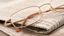 eyeglasses resting on a folded newspaper eyeglasses resting on a folded newspaper