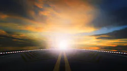 sun rising in the sky above an asphalt highway. sun rising in the sky above an asphalt highway.
