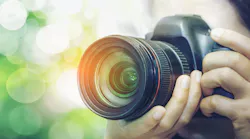 hands holding a camera and aiming at something off the screen. Green background. hands holding a camera and aiming at something off the screen. Green background.