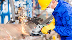 Industrial worker in manufacturing plant grinding to finish a pipeline Industrial worker in manufacturing plant grinding to finish a pipeline