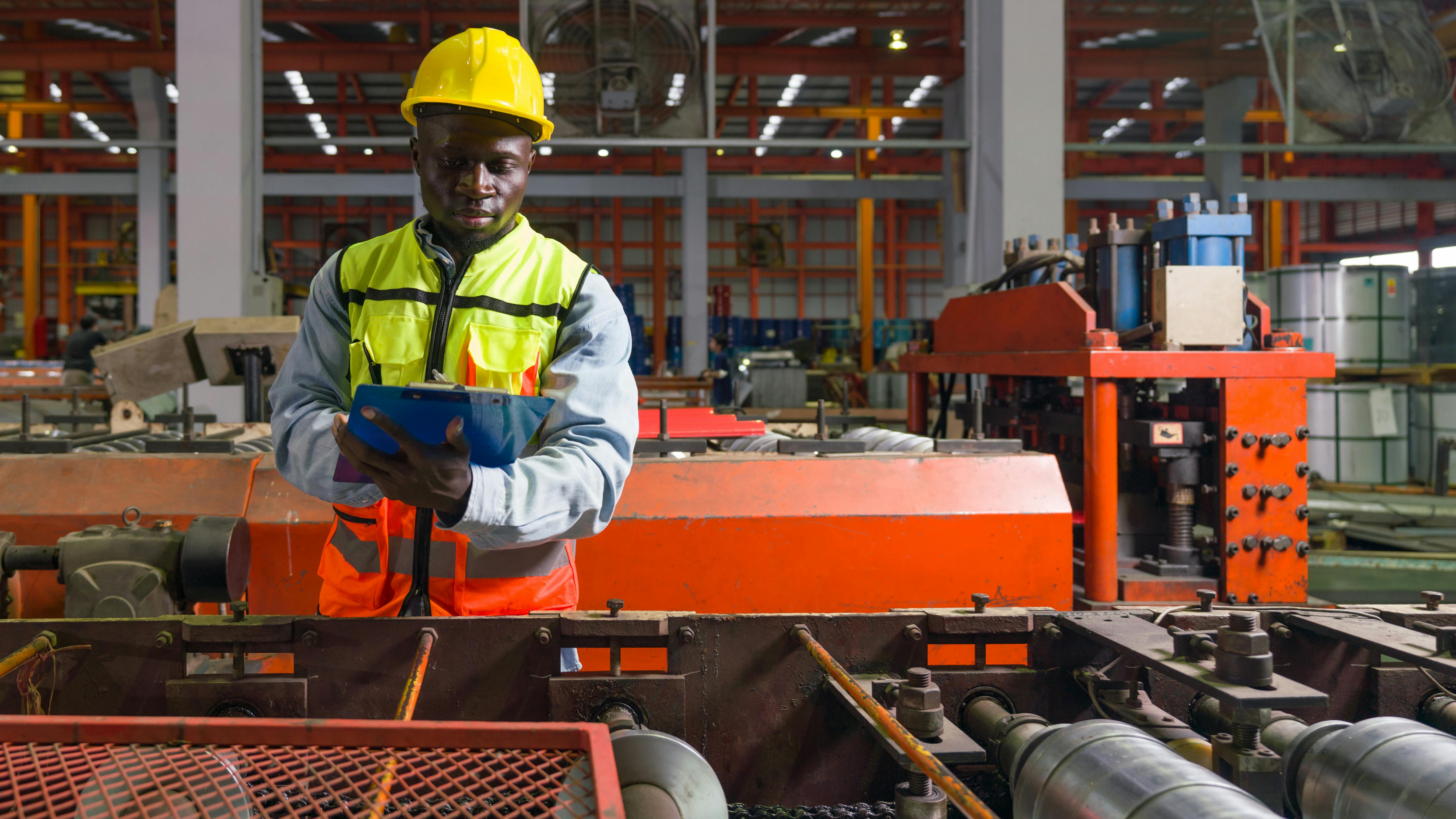 A factory worker standing near a production line conveyor belt