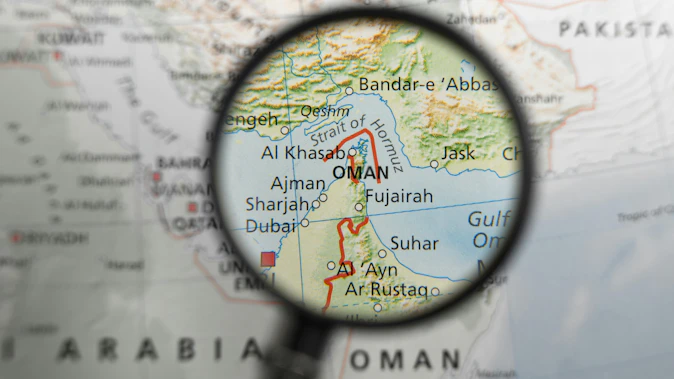 Map of Strait of Hormuz and surrounding area under magnifying glass.