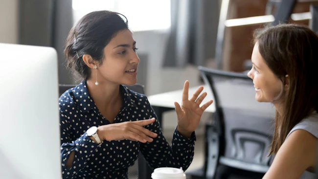 Female colleagues having a conversation at the workplace.