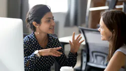 Female colleagues having a conversation at the workplace.