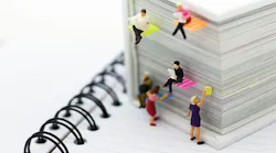 Miniature people: businessmen reading newspaper on a big book.