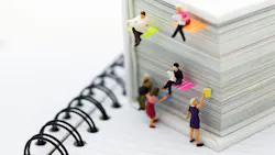 Miniature people: businessmen reading newspaper on a big book.