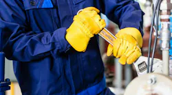 body of person holding a wrench and working on equipment