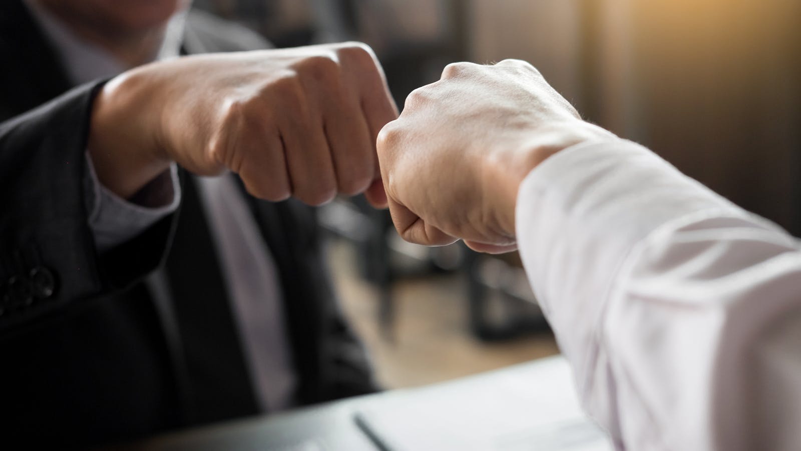 a close up of a fist bump between two people