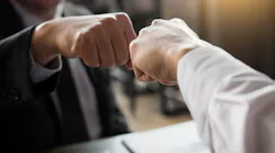 a close up of a fist bump between two people