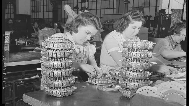 Workers assemble solonoid selectors that switch records in jukeboxes, 1942. The Wurlitzer plant was about to be converted to wartime use manufacturing electrical control devices for the military.