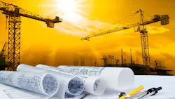 architectural plan on unseen table with construction equipment, such as cranes, in the background.
