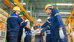 Workers and manager cheering for achievement in workshop