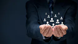 Businessman holding glass cubes with icons representing group of people.