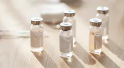 Ampoules, syringes and cotton pads on wooden table