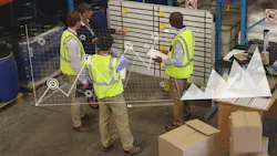 group of people gathered around whiteboard, industrial setting