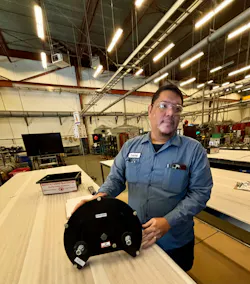 Production Manager Christian Apanay displays applicator hardware specially designed for the Australian rail system.