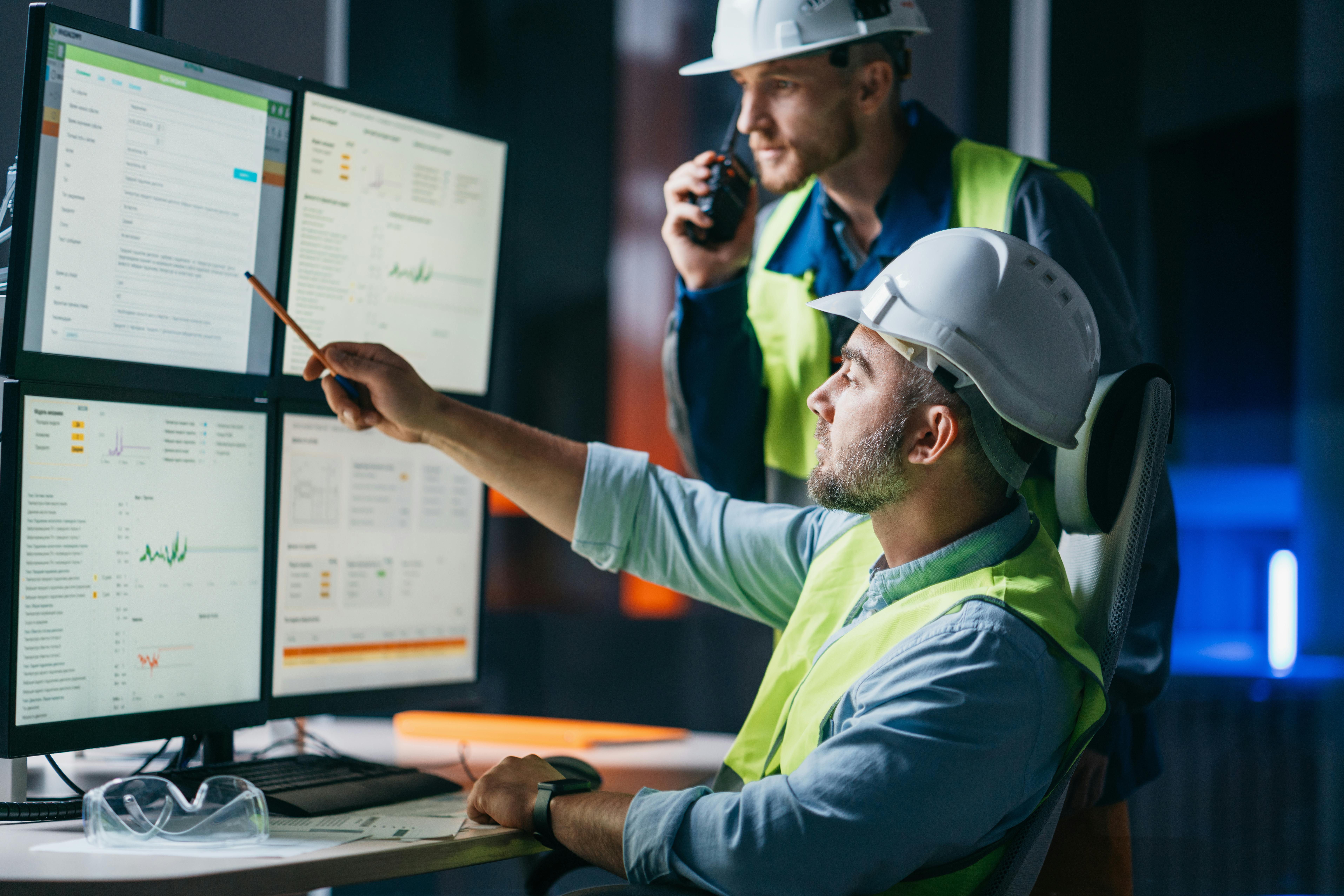 Two manufacturing leaders go over an ERP system in a factory.